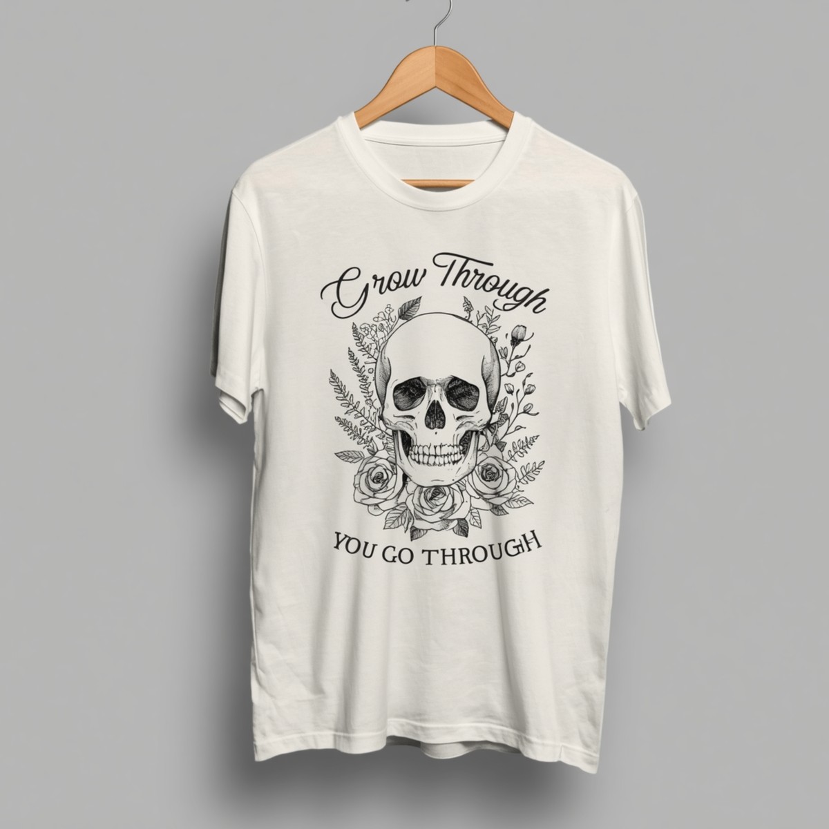 T-shirt blanc à manches courtes avec illustration tête de mort entourée de roses et de feuilles sur le devant